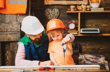 Baba oğluna tornavida ve çekiç kullanmayı öğretiyor. Alet inşaatında çalış. Çocuk büyüme kavramı