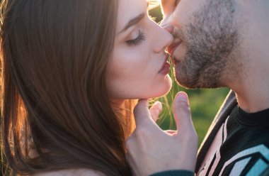 Şehvetli, genç bir çift, erkek ve kadın, öpüşmeye yaklaşıyorlar, alay ediyorlar şefkatin ve samimiyetin tadını çıkarıyorlar, arzuları hissediyorlar.