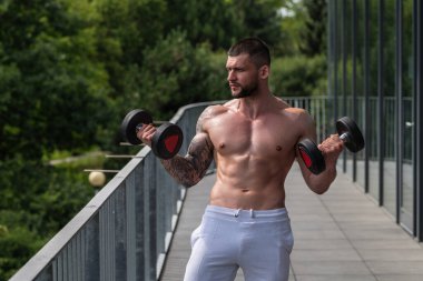 Motivated male athlete does exercise, bodybuilding workout at gym. Strong muscular man has fitness workout. Sport and healthy lifestyle concept. Muscular man workout in gym doing exercises with