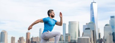 NYC 'de spor kıyafeti giymiş İspanyol bir koşucu. Hareket, sağlıklı koşu. Manhattan yakınlarında koşan bir koşucu. Kaslı sporcu şehirde koşuyor. Spor kıyafetleri. Egzersiz yapan yakışıklı adam.