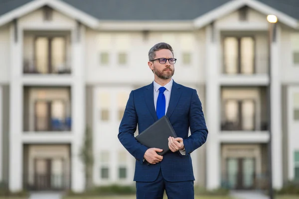 Real estate agent business man in suit hold holder clipboards outside. Hispanic Businessman. Business Man broker or real estate agent. Business man in suit outdoor. Real estate business man