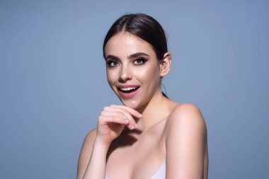 Mutlu genç bayan kameraya bakıyor ve gülümsüyor. Güzel gülümseyen genç bayan. Güzel kız gülümseyerek gülümsüyor. Mutlu ve gülümseyen kadın yüzü. Otantik mutlu kadın portresi