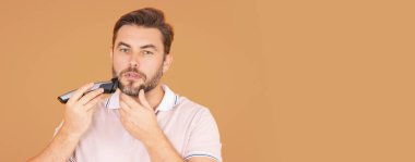 Makaslı adam. Adam kuaför makasıyla saç kesiyor. Stüdyoda erkek tıraşı. Berber makası. Erkekler sakal keserler. Elinde makas tutan adam. Başlık için afiş, kopyalama alanı. Web tasarımı için poster