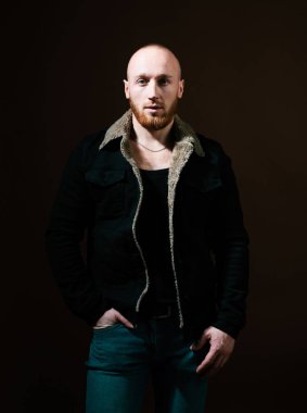 Yakışıklı bir gencin portresi. Moda adamı. Tarz ve trend. Yakışıklı, özgüvenli çocuk siyah arka planda duruyor. Metnin ya da reklamın için fotokopi alanı var.