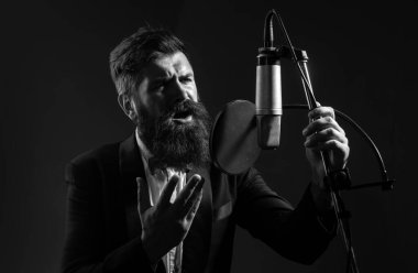 Kayıt stüdyosundaki yakışıklı adam. Müzik performansı vokali. Müzik festivali. Şarkıcı mikrofonla şarkı söylüyor