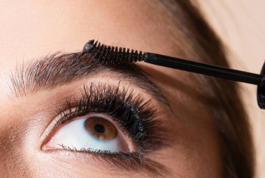 Güzel kaşları olan kadın gözü. Mükemmel şekilli kaş, kaş jöleli kirpikleri. Kahverengi kaşları şekillendiren kadın model. Makro, kaşları kapat.