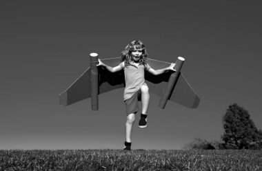 Mavi gökyüzüne doğru uçan kağıt kanatlı mutlu çocuk. Oyuncak jetpack ile oynayan bir çocuğun portresi. Özgürlük tasasız, başarı kazanan, yenilik ve hayal gücü kavramı