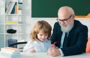 Okuldaki mutlu çocuk. Öğretmenin öğrenmesine yardım et. Eğitim, öğretmenlik, ilkokul