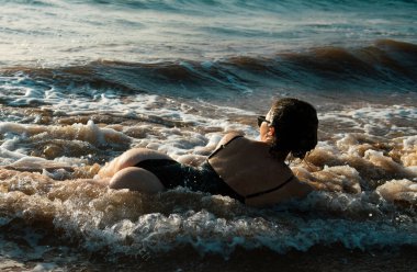 Back view sexy young woman posing on the beach. Beautiful woman relaxing at the ocean. Sexy curves girl butt