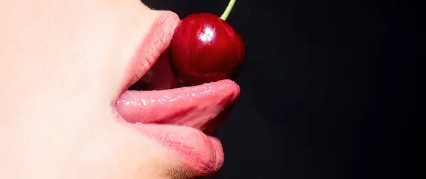 Cherry in woman mouth. Cherries on woman lips. Tongue lick cherry, macro, close up. Summer sexy fruits, banner