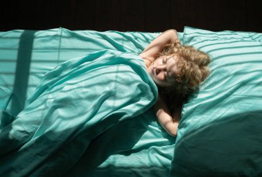 Çocuklar uyuyor. Yatak odasında çarşaf ve yatak.