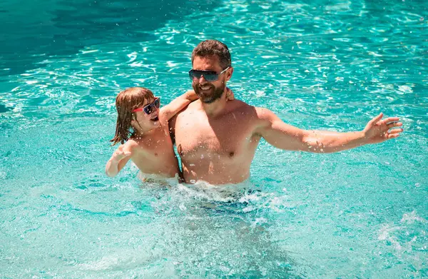 Father and son swimming in pool, summer family weekeng