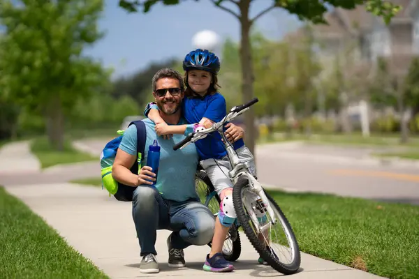 父亲节 爸爸教儿子骑自行车 快乐温馨的家庭 父子俩拥抱在一起父亲在户外和儿子玩耍 父亲抚养孩子 父亲的爱 娇小的孩子 — 图库照片