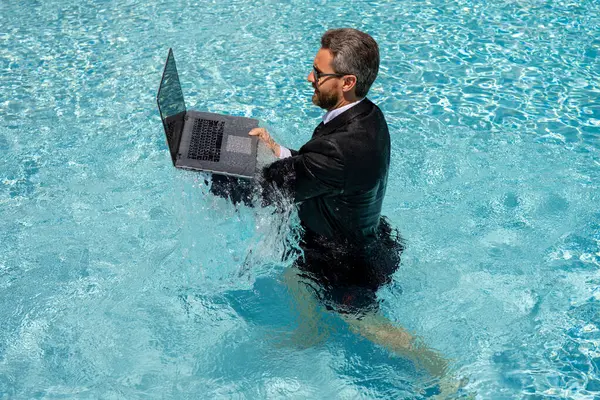 Çılgın iş adamı yüzme havuzunda rahatlıyor. Yaz tatili, deniz sahilinde iş. Yaz tatili, iş adamları konsepti. Zengin iş adamı yüzme havuzunda dinleniyor. Uzak çalışma