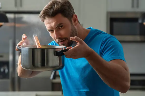 Man chef cooking food in pan pot in kitchen. Process of preparing gourmet dish. Man cooking at home in kitchen, using pot. Chef cooking food. Handsome chef cook cooking concept