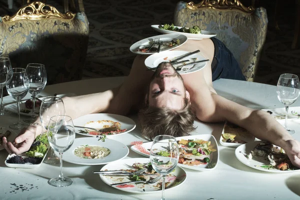 Adam deli gibi yiyor. İştah ve diyet. Yemek masasında akşam yemeği. Lokantada alem yapan komik bir adam. Deli gibi yiyen adam. Yemeğin tadına bak ve abur cubur ye. Lezzetli yemek. Seksi Vücutta Boş Tabak