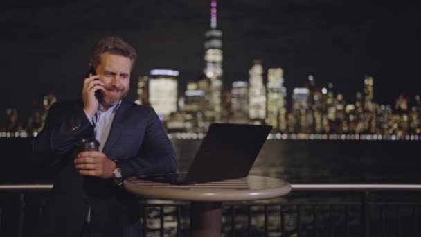 Biznesmen Garniturze Używający Laptopa Rozmawiający Przez Telefon Świeżym Powietrzu Nocy — Wideo stockowe