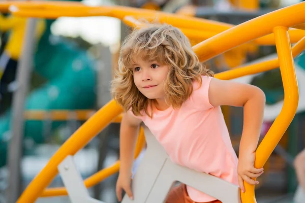 Çocukluk. Küçük çocuk oyun alanında oynuyor. Mutluluk duygusu, eğlence, neşe. Bir çocuğun gülümsemesi.