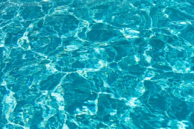 Yüzme havuzunda güneş yansımalı dalgalı su. Dalgalı su arkaplanı
