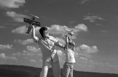 Torunum ve büyükbabam mavi gökyüzünde ve bulutların arkasında uçak ve kuadkopter drone ile