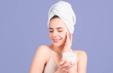 Kozmetik ürünler. Güzel yüz portresi. Spa terapisi, havluyla güzel bir kadın cildiyle ilgilenir.