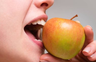 Sağlıklı dişler ve elma. Diş bakımı. Elma ısıran bir kadın. Ağzını kapat.