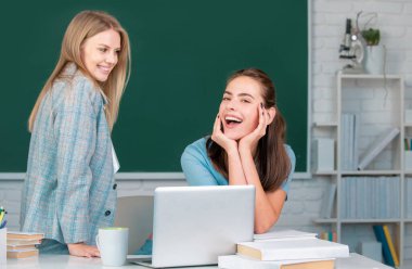 Öğrenci kızlar okuldaki sınıfta birlikte okuyorlar.