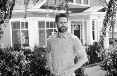 Yeni evin önünde duran yakışıklı adamın portresi.