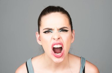 Çığlık, nefret, öfke. Düşünceli bir kadın öfkeli, kızgın ve çılgın bir stres hissediyor. Üzgün ve kızgın bir yüz. Bağıran ağız, çığlık atan yüz