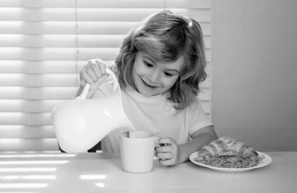 Pretten child pouring whole cows milk. Kid bot eating meal. Healthy nutrition for children. Child enjoy eating for breakfast or dinner with appetite. Hungry child eat tasty fruits and vegetables