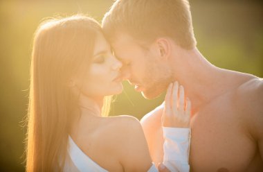 Şehvetli bir öpücük. Adam gün batımında hassas bir kadını öptü. Aşık genç bir çiftin şehvetli portresi. Sevgi dolu çift kucaklaşıp öpüşüyor.