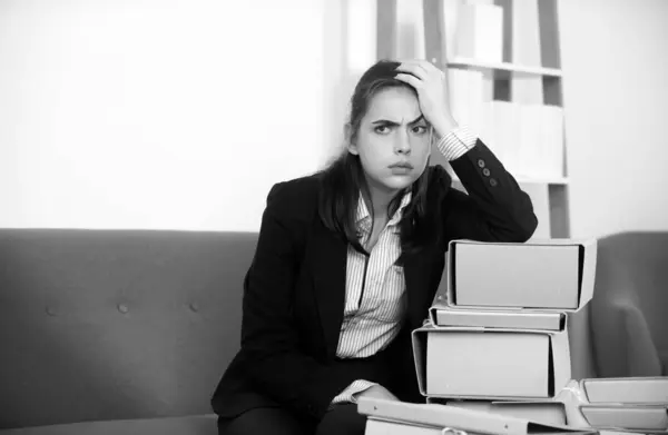 Upset business woman on folders with the documents, unhappy secretary girl working overtime at office. Problem solution