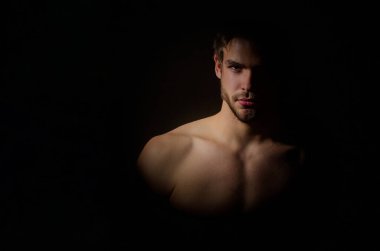Erkek stüdyo portresi. Genç bir adamın siluet portresi. Gölgelerdeki adam. Karanlıkta kaslı seksi vücut silueti. Stüdyoda gölgeli genç erkek yüzü. Modellerin yüzlerinin stüdyo görüntüleri.
