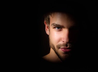 Erkek yüzü yakın çekim. Seksi erkek yüzü, stüdyo resmi. Çekici bir adam gölgede, kameraya bakıyor. Gölgelerdeki genç adamın seksi ve çekici yüzü. Güzel seksi model yakın plan. Yüzler