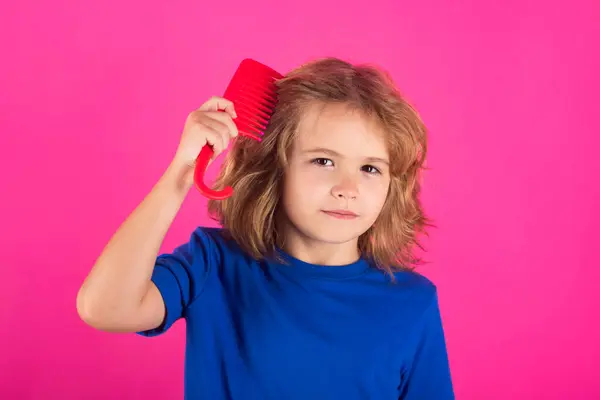 Comb and hair brush concept. Funny kids hairstyle. Kid brushing tangled hair. Funny kids haircut