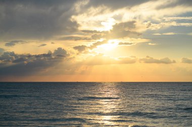 Sunset sea landscape. Colorful beach sunrise with calm waves. Nature sea sky. Seascape in summer morning. Sunrise with clouds of different colors against the blue sky and sea