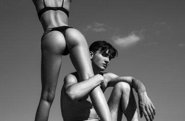 Womens legs and butt. Sexy hot girl wearing luxury bikini bottoms. Sexy couple in love. Sensual boyfriend embraces lovers. The concept of tenderness and affection
