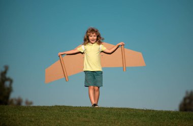 El yapımı el yapımı kağıt uçak kanatları olan sevimli sarışın çocuk oyun pilotu portresi. Çocuklar rüya görür, başarı, yaratıcı ve başlangıç konsepti. Metin için alanı kopyala