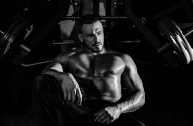 Eğitimden sonra yorgun sporcu dinleniyor. Bir şişe suyu ya da proteini olan bir adam. Spor salonundaki sporcu.