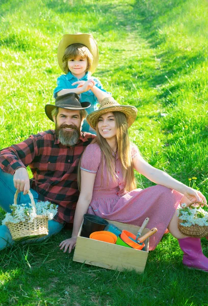 Gardener happy family on spring picnic in garden or park. Parenthood together leisure concept