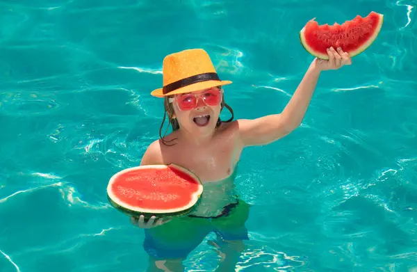 Child eat watermelon in the pool. Child in swimming pool. Summer kids activity. Summer vacation. Healthy kids lifestyle