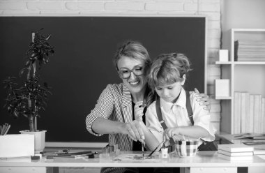 Öğretmenle birlikte öğrenen çocuklar. İlkokuldan çocuklar derste. Öğretmen ve küçük öğrenciler portresi, öğretmenler günü