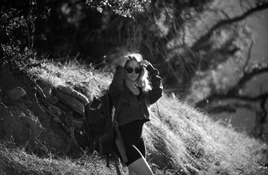 Dağda sırt çantalı bir kadın yürüyüşçü. Panoramik noktada tepeye tırmanan bir kız. Turizm konsepti