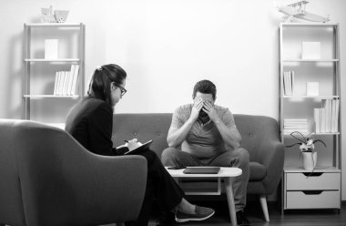 Bunalımlı orta yaşlı adam sorunu terapisi. Psikiyatrist ile terapi seansı sırasında psikolojik sorunlarını tartışan bir adam.