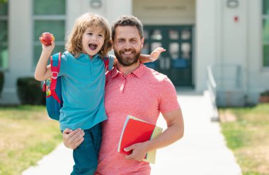Öğretmenler günü. Okullu çocuk babamla aynı okula gidiyor. Babam ilkokulda küçük bir çocuğu yönetiyor.