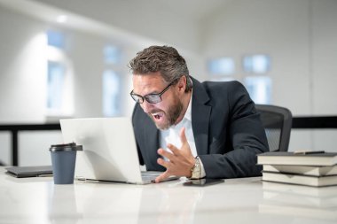 Ofiste dizüstü bilgisayarla çalışan kızgın bir iş adamı. İşadamı yönetici dizüstü bilgisayar kullanıyor. Ofis işyerinde milenyum müdürü. Ofis çalışanları, iş adamları.