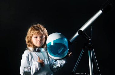 Çocuk uzayı keşfediyor. Uzay elbiseli ve teleskoplu şirin çocukların portresi. Kozmonotik gün konsepti. Astronomi ve astroloji kavramı