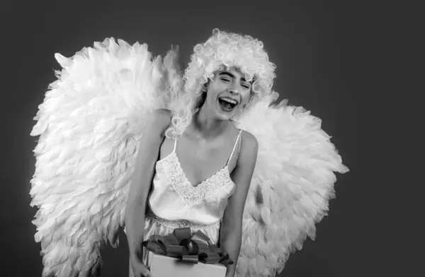 Funny blonde angel girl with white wings. Fallen white angel