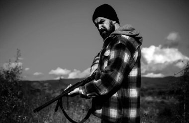 Avlanan av tüfekli bir avcı. Sınırsız avlanma. Avcı için kıyafetler. Amansız Avcı 'nın Portresi