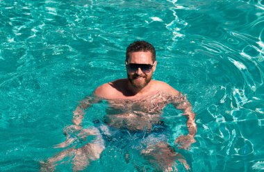 Havuz kaplıcası. Yaz tatilinde bilardoda. Yaz haftasonu. Yüzme havuzunda yakışıklı bir adam